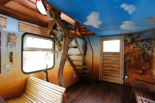 Лесная сцена, нарисованная внутри вагона поезда, переделанного в Airbnb