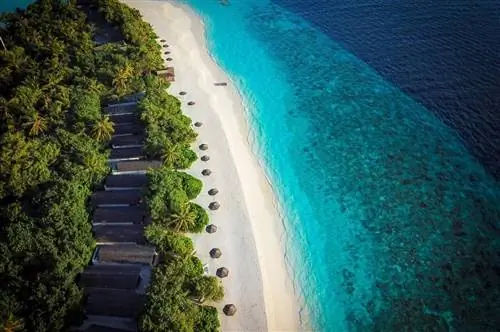 Аэрофотоснимок пляжных хижин на Мальдивах в Reethi Beach Resort.