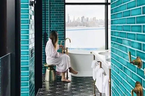 Женщина смотрит в окно отеля The Williamsburg, Бруклин, Нью-Йорк.