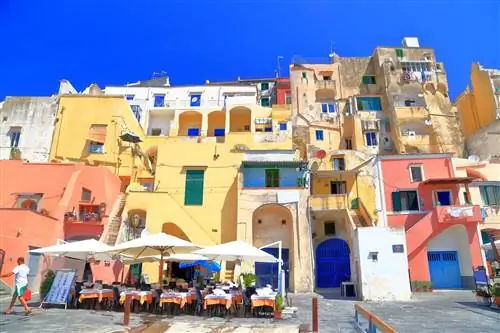 procida-italy-ресторан-с-видом-на пристань и мужчина, проходящий мимо