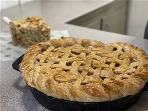 25-фунтовый яблочный пирог на столе с кусочком пирога на заднем плане - кукольная еда