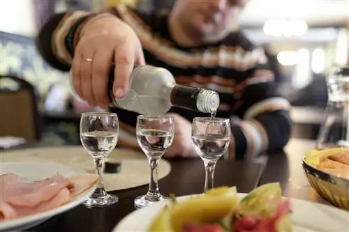 мужчина наливает водку