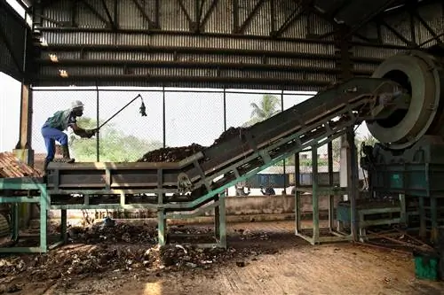На компостном заводе, обслуживаемом в рамках Проекта управления твердыми отходами KMDA, рабочий использует машину для приготовления компоста. (Субрата Бисвас/AP Images для C40)