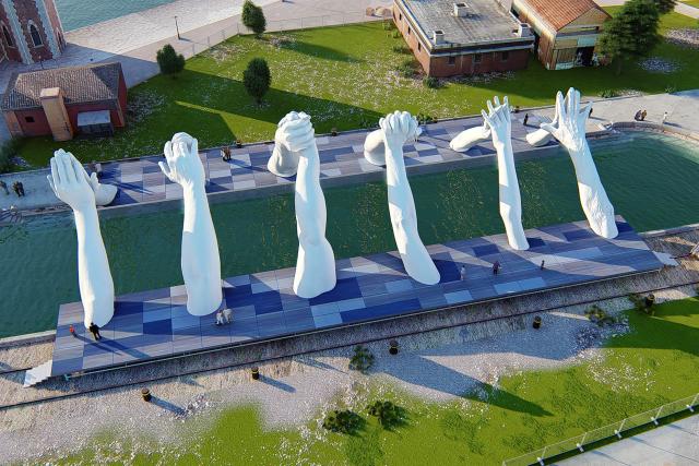 Массивная скульптура рук захватывает внимание толпы в Венеции